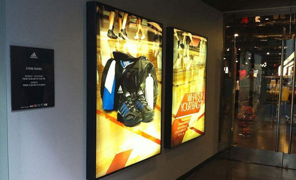 Backlit media window displays creating illuminated storefront signage for retail. 