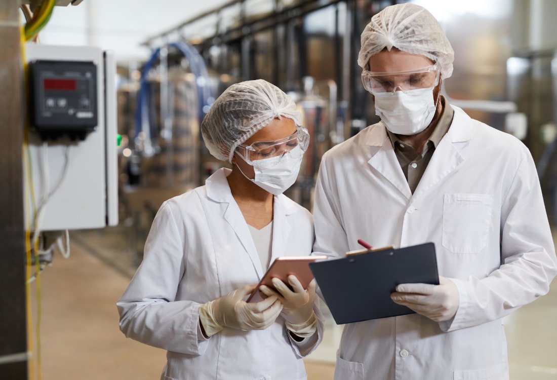 Two lab technicians in a laboratory assessing the static mixing process in their pharmaceutical laboratory.  
