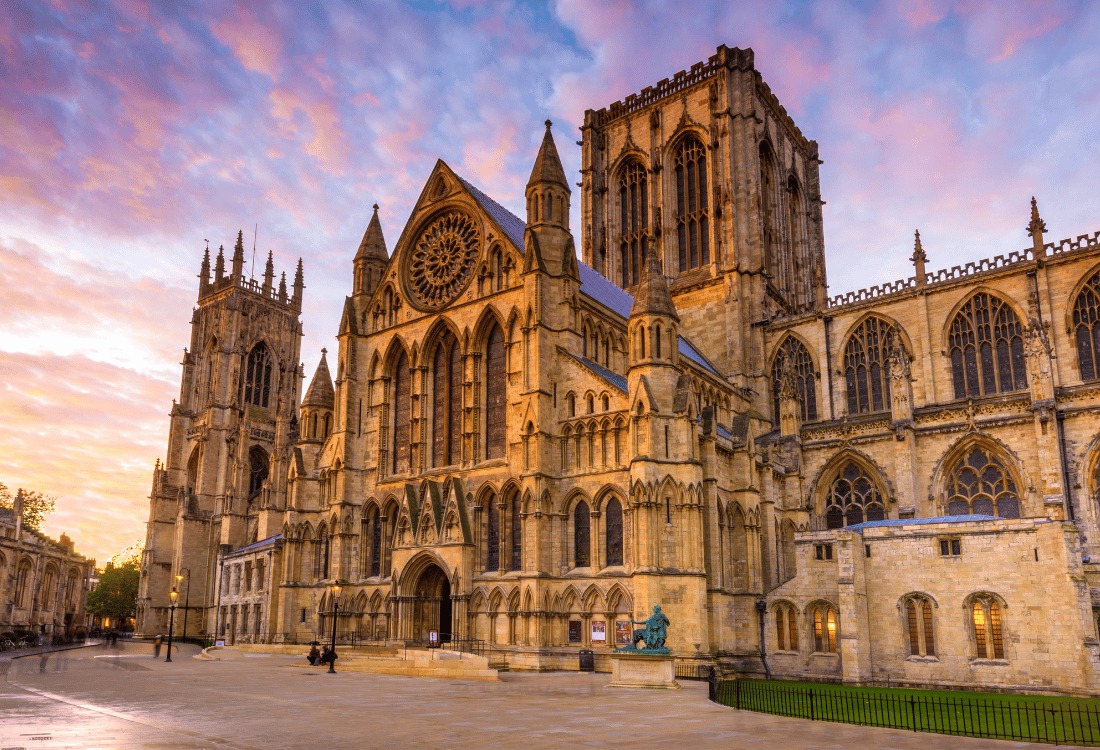 Panoramic view of York Minster, showcasing its grand Gothic architecture and intricate details under a wide sky.