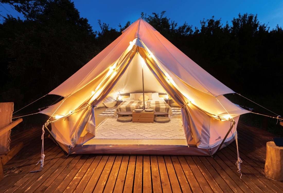 A glamping yurt set up for guests, featuring an adjacent modern shower pod for added comfort and convenience.