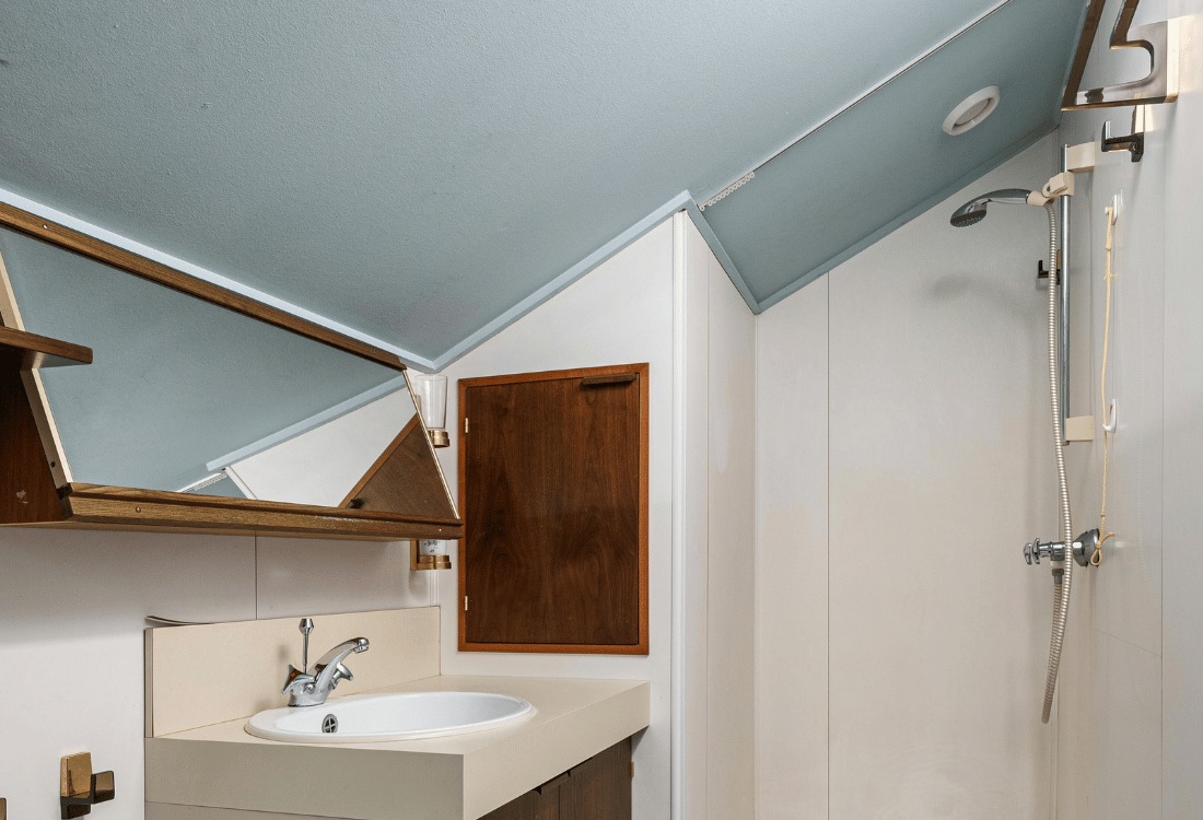 A compact sloped bathroom ready to be fitted with a custom shower pod.