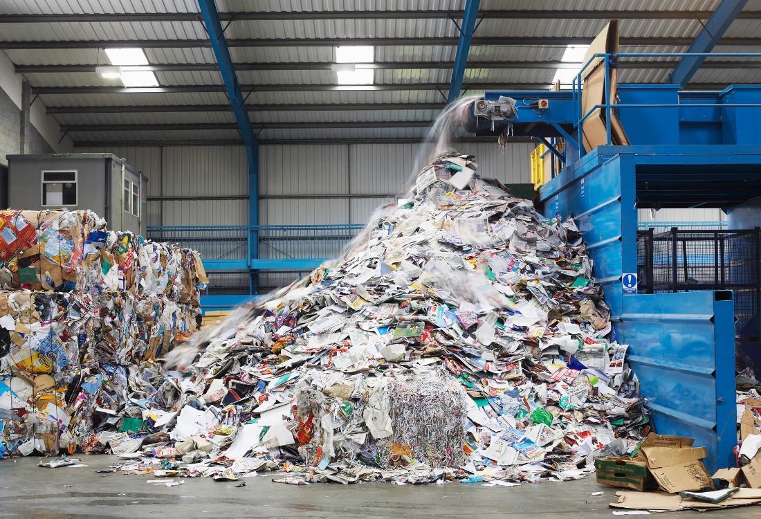 Waste and dust emissions coming out of a machine in a recycling factory.