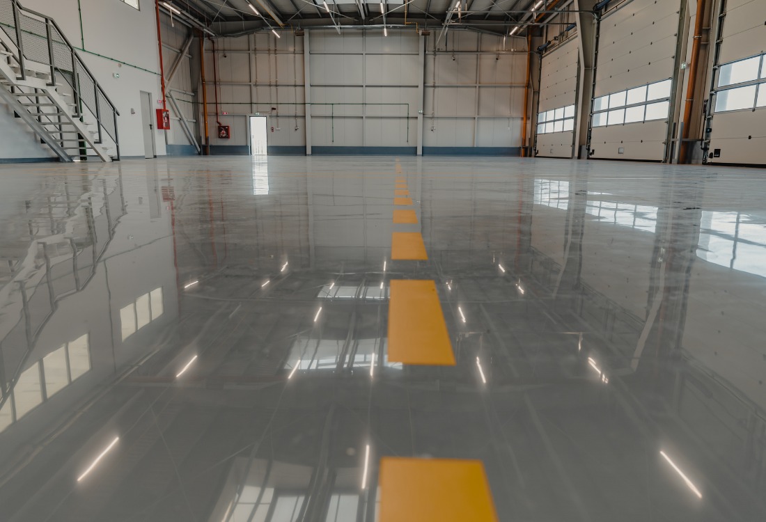 Warehouse epoxy flooring with demarcations indicating separated spaces.