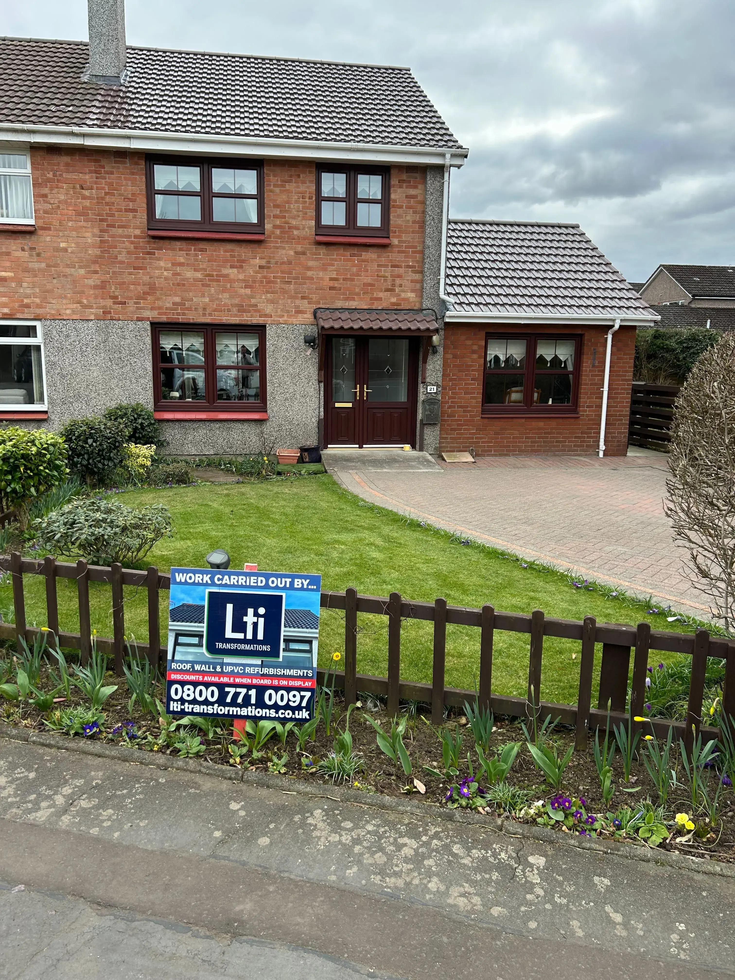 Two-storey Scottish home with a refurbished roof and an LTI contractor sign displayed in the front garden.