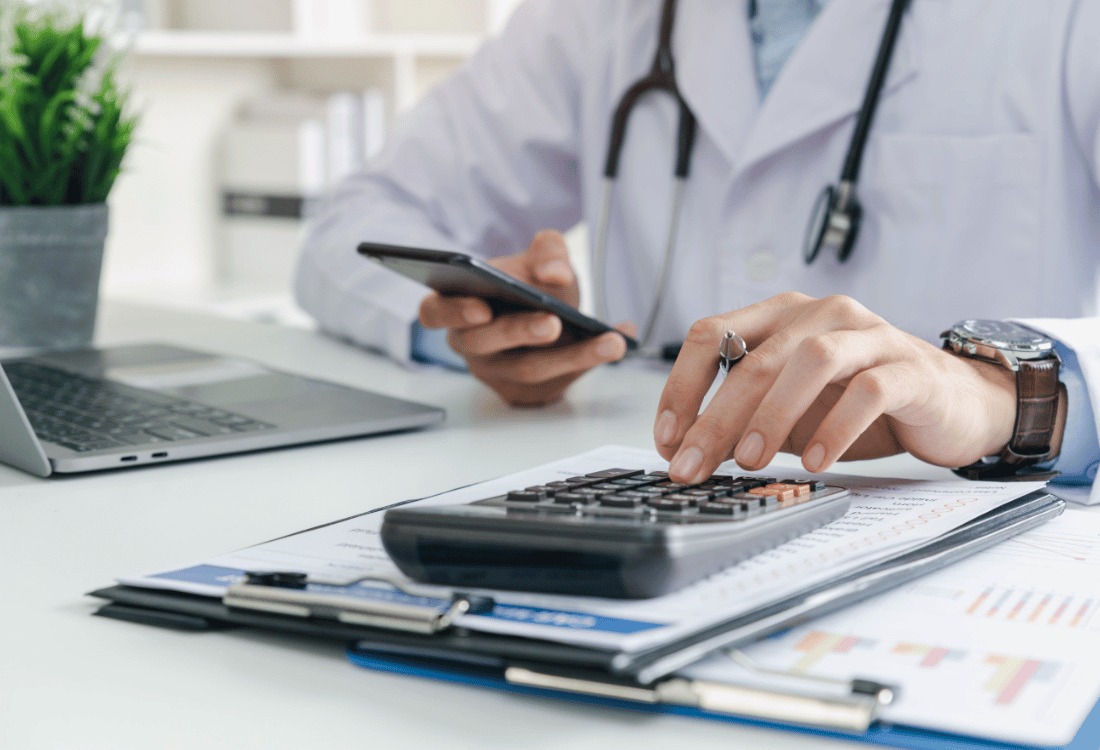 Doctor manually calculates medical expenses, showing just how online accounting can streamline accounting for healthcare providers