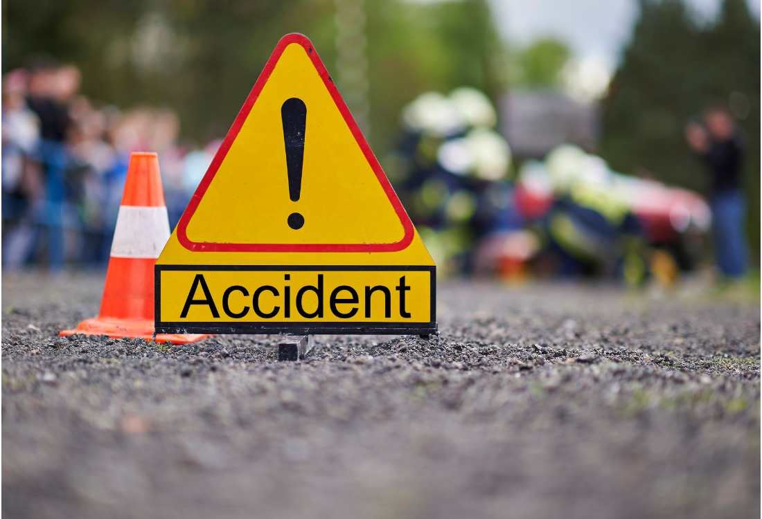 Red triangular road sign warning of an accident ahead on the road.