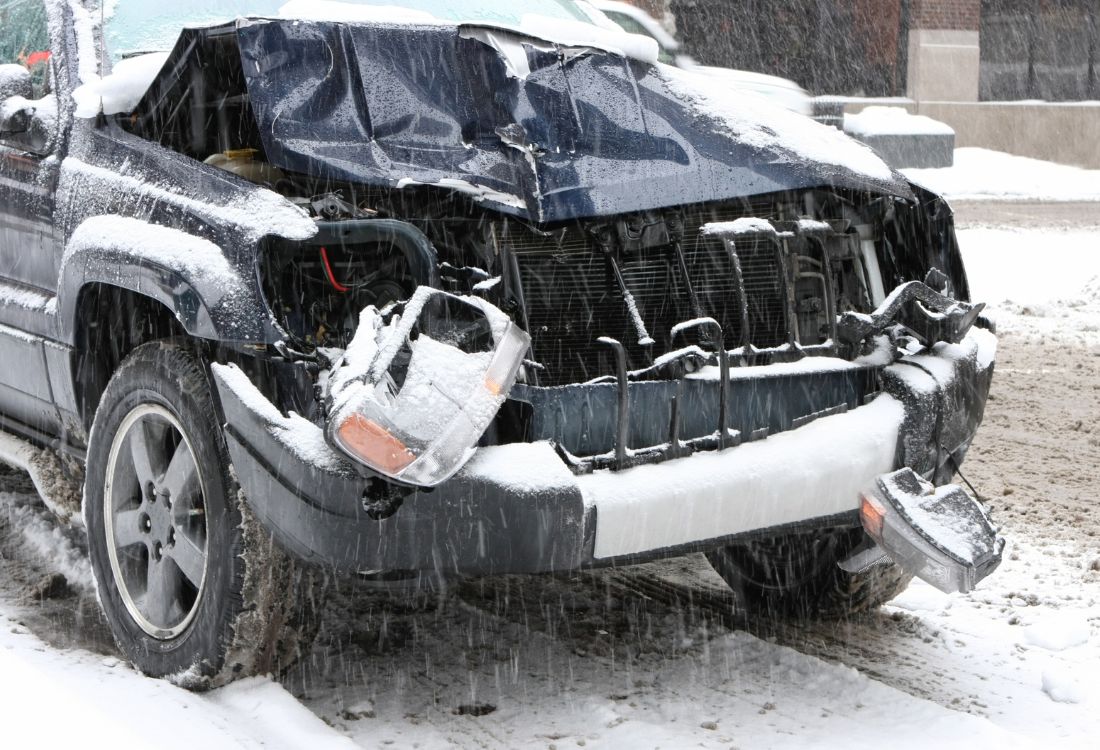 Car damaged in a winter accident after sliding on icy roads, highlighting the importance of safe driving tips and insurance-approved repairs.