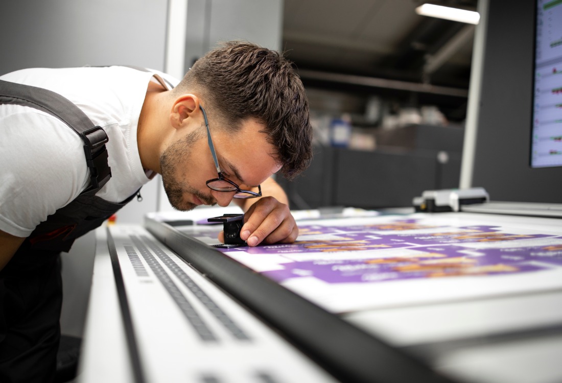 Technician examining the superior print quality provided by advanced platemaking systems. 