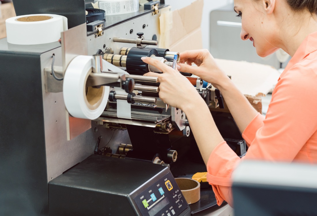 Woman operating a label printing machine.
