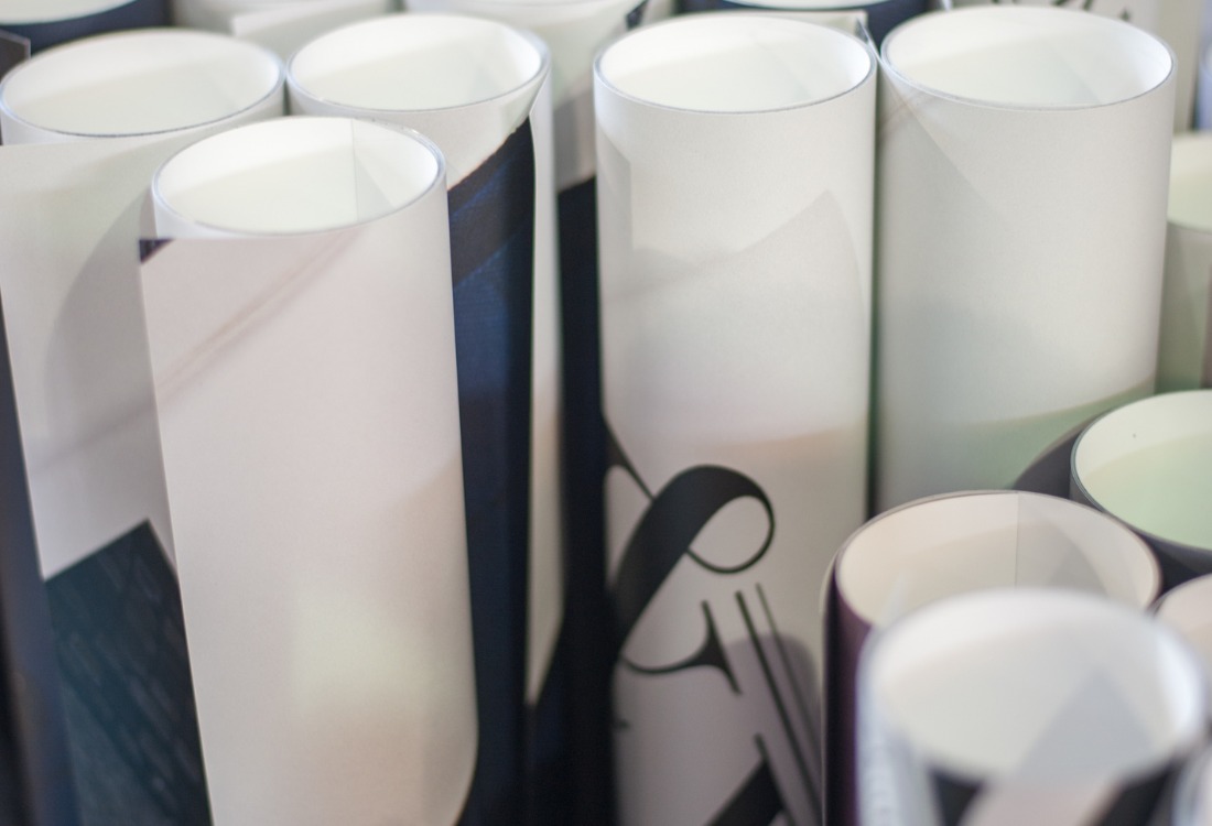 Rolled large format prints standing upright, showcasing vibrant graphics and designs ready for display.