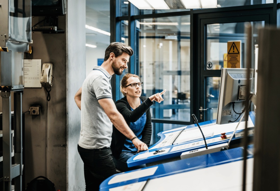 Expert technicians reviewing production settings on advanced printing equipment.