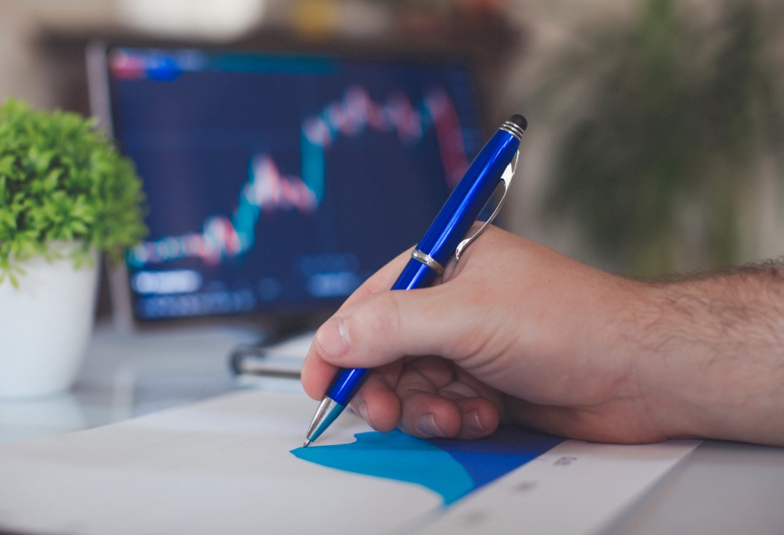A close up of a person writing on their cashflow forecast graph in pen.