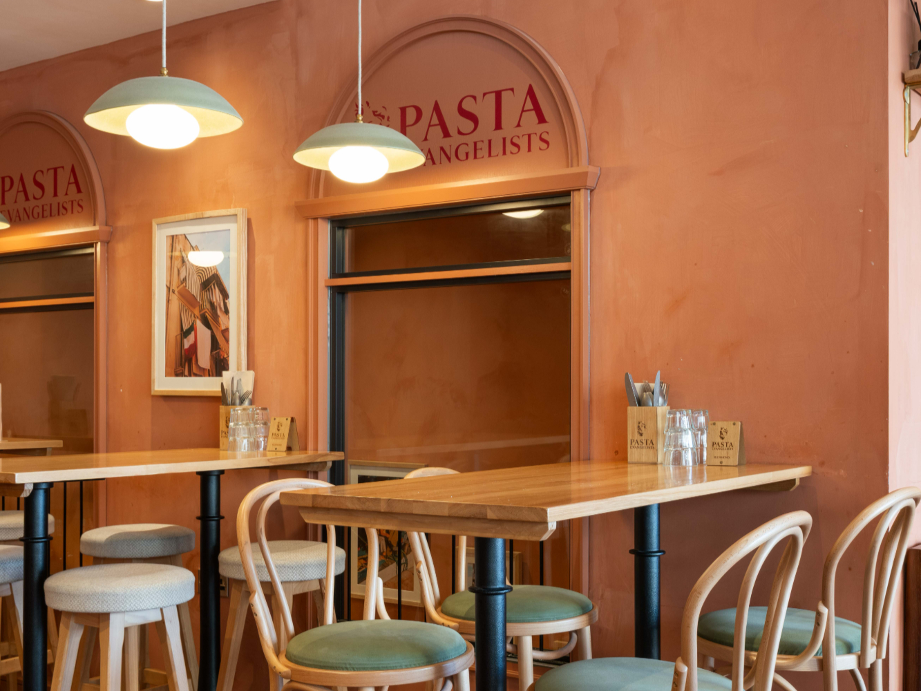 The interior design of a restaurant, highlighting the business brand thanks to the colours and materials used.