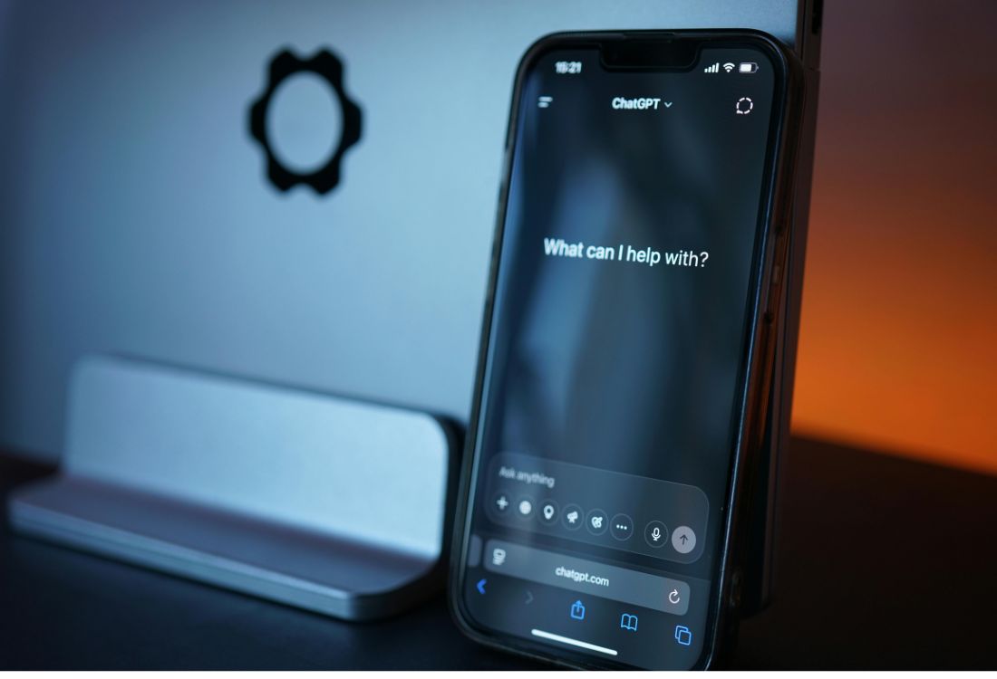 Smartphone showing AI assistant interface on a desk.
