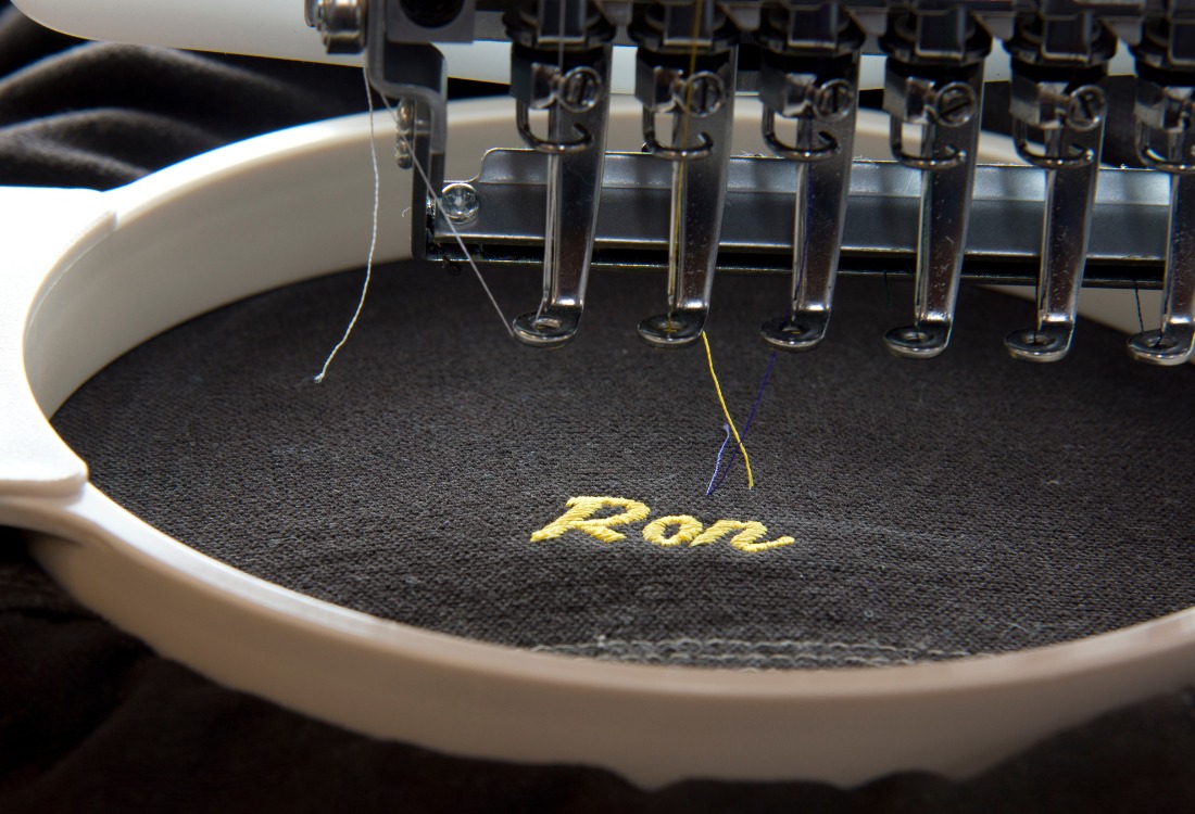 A jumper being custom embroidered on an embroidery machine. 
