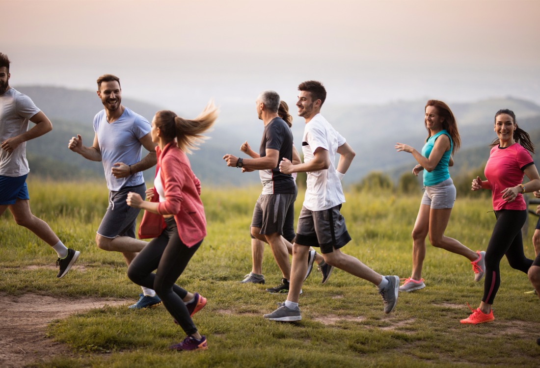 A large group of people engaged in sports activities, in this case jogging, illustrating the community and economic benefits of sports and leisure in England.