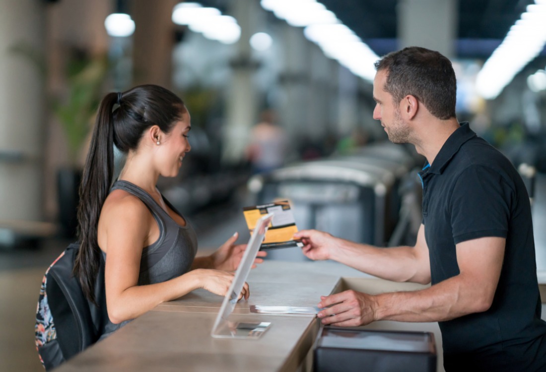 A leisure centre receptionist assisting a customer at the front desk, highlighting the importance of continuity, service quality, and strategic planning as leisure management contracts near expiry.