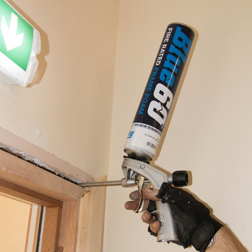 A man using Blue60 to seal his fire door to help reduce costs and save time.