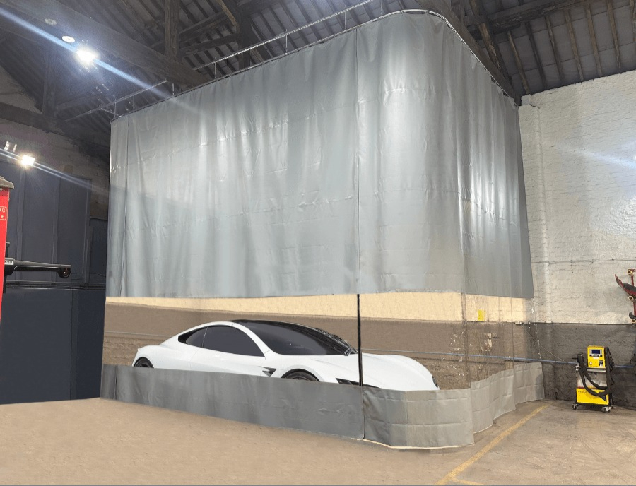 Flexible PVC curtain partitioning installed in automotive warehouse creating enclosed work area around white car, demonstrating industrial partitioning solution for vehicle storage and maintenance.