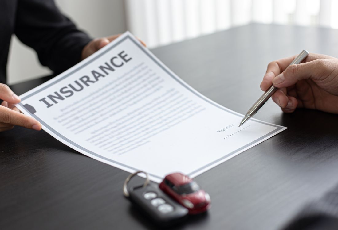 Person reviewing and signing an motor trade insurance documents.