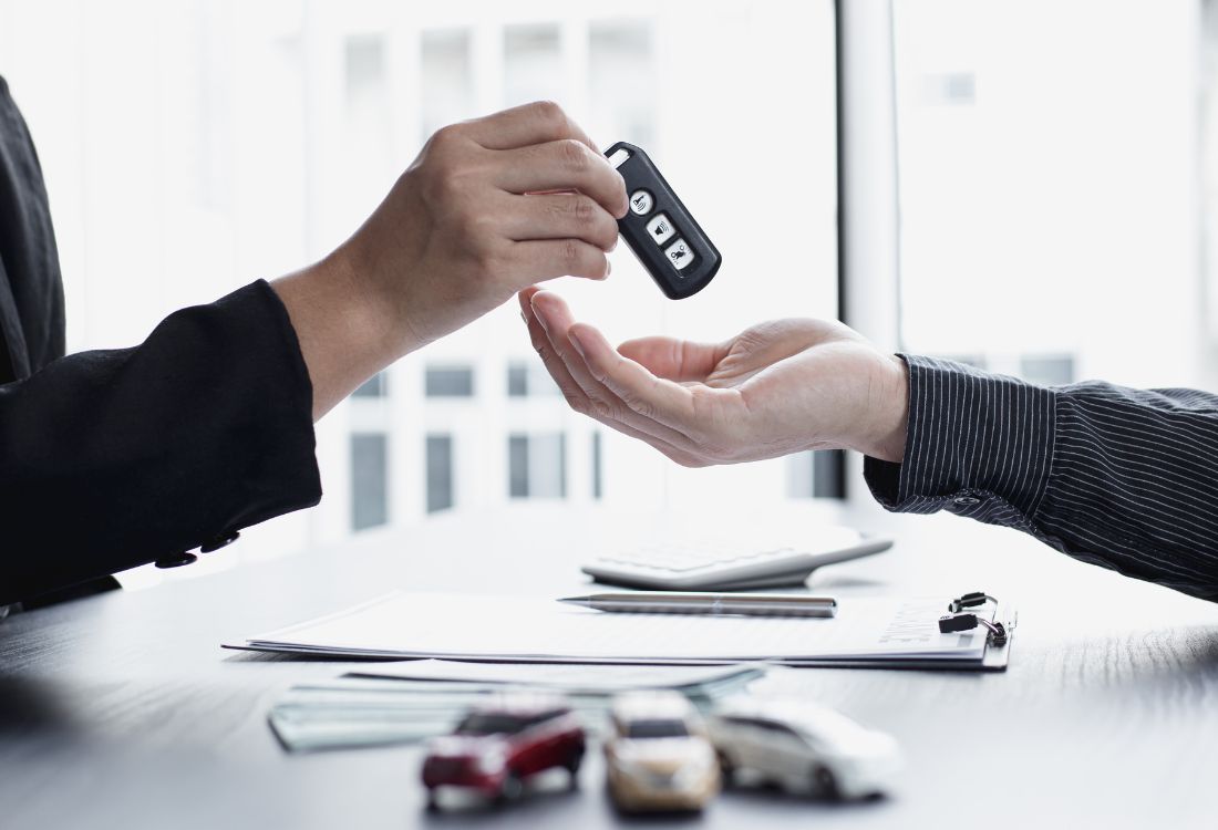 Car keys being handed over during a motor trade insurance transaction.