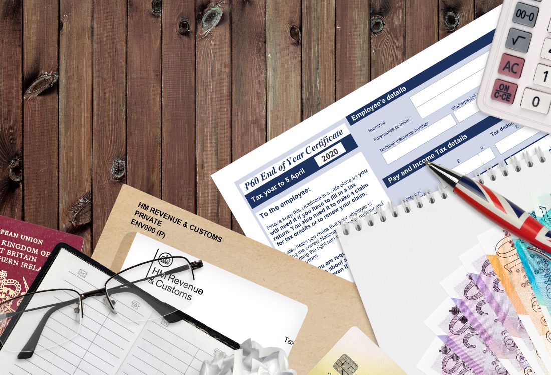 Assorted financial documents, receipts, and a P60 form laid out on a desk with stationery.