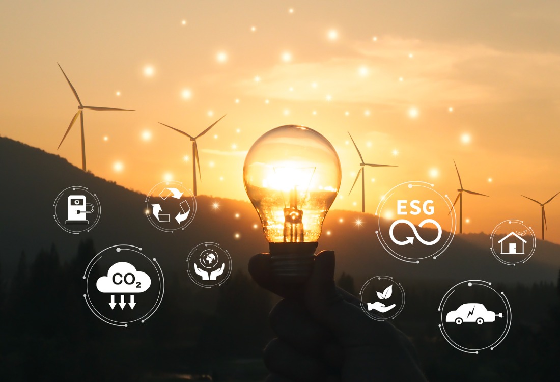 Wind turbines silhouetted against sunset with illuminated light bulb and floating sustainability icons including CO2 reduction, ESG, recycling, and electric vehicles, representing the UK's Clean Power 2030 transformation.