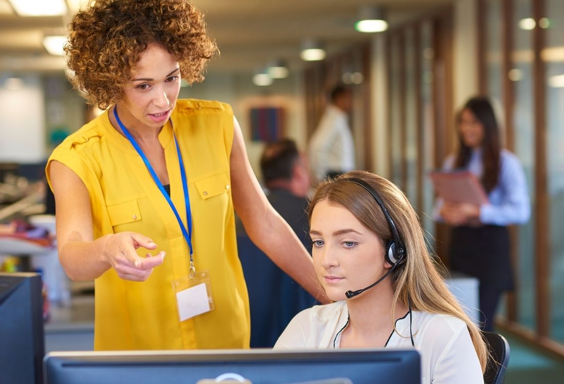 A young woman doing her apprenticeships off-the-job training with the help of her manager.