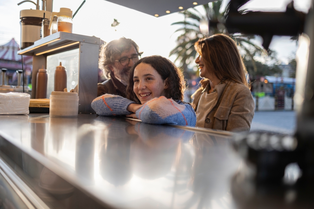 Bystander supporting child learning independence in public - parent teaching real-life skills