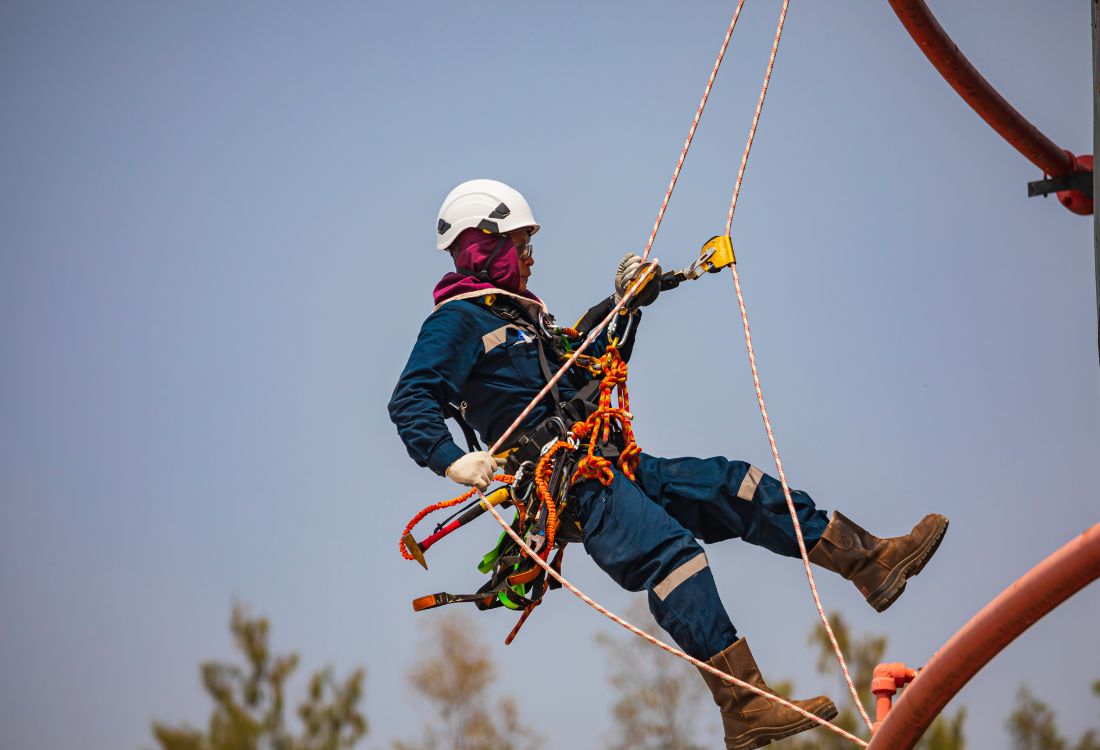 A man using rope access to gain access to the top of a turbine.