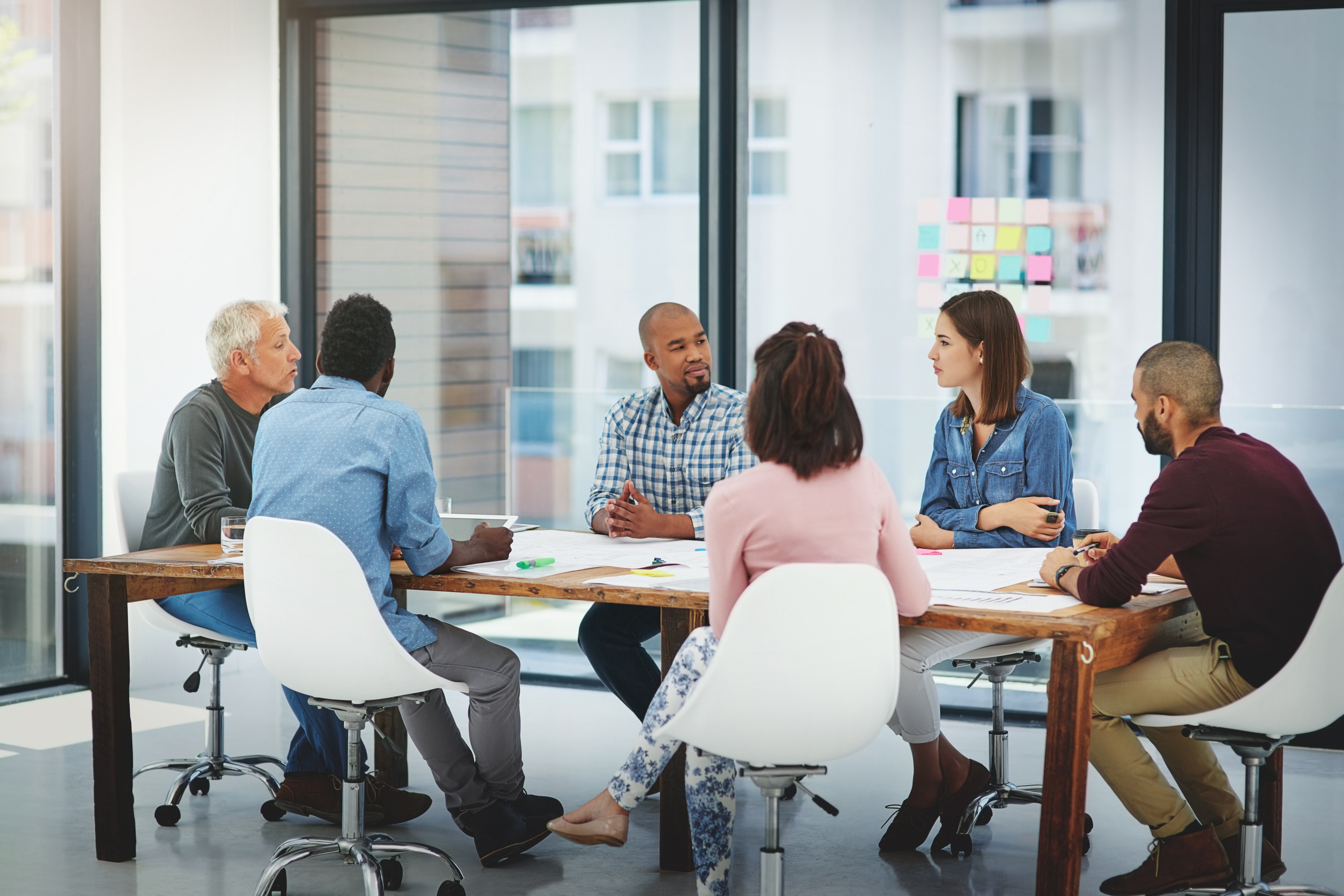 Creative people, meeting and discussion with team for collaboration, planning or brainstorming at office. Group of employees talking in boardroom or conference for ideas in startup at workplace.