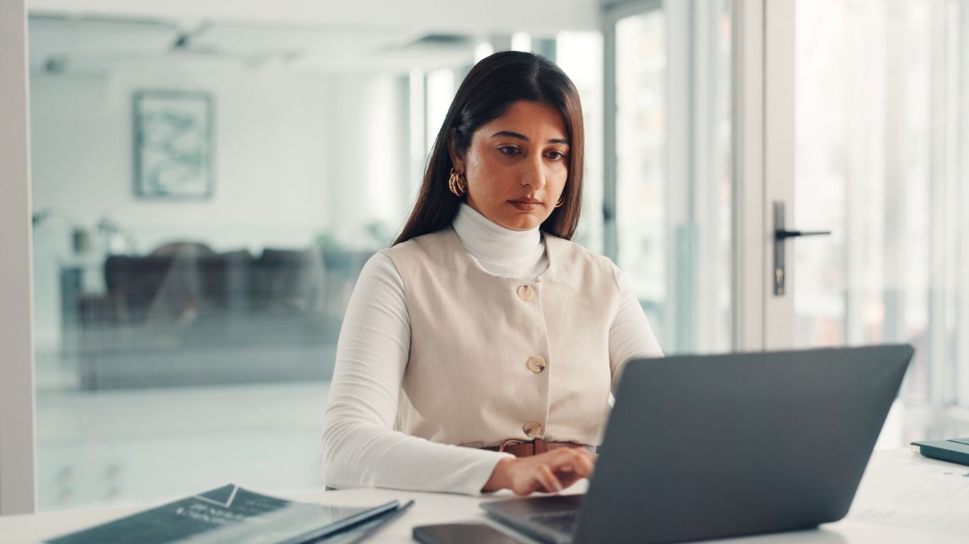 An auditor working on a laptop to manage Audit Turnaround Time.