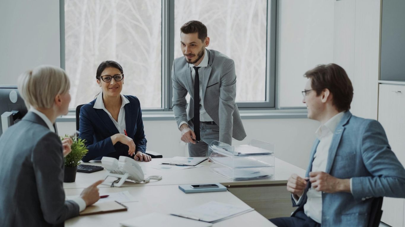 Managers gathered around a conference table discussing data after Reading QC Reports.