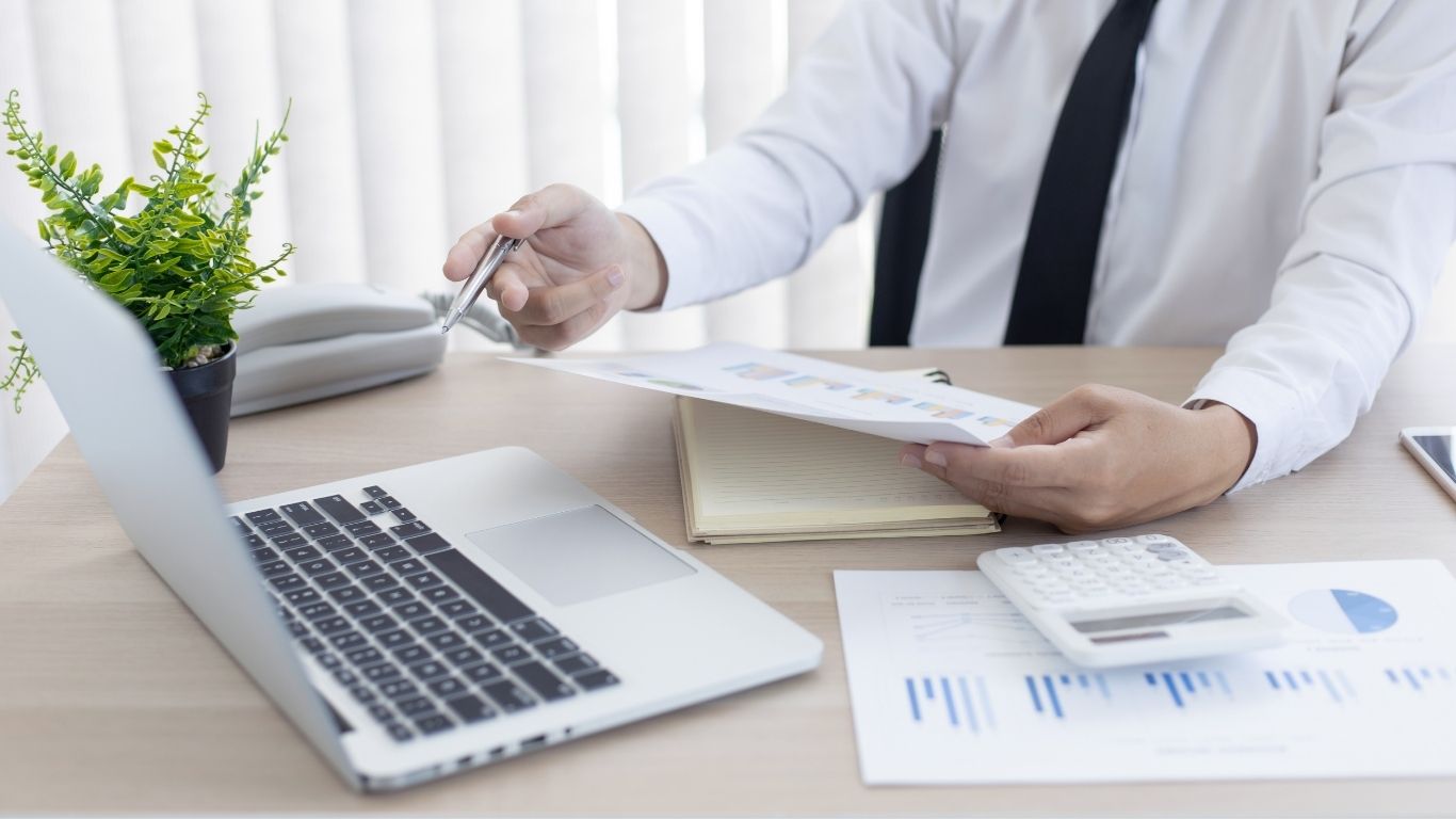 A person pointing to financial charts and documents during a Mortgage Audit.
